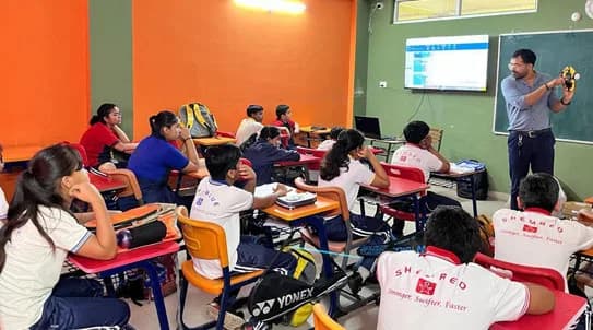 A GSL trainer leading a robotics session in a partner school classroom